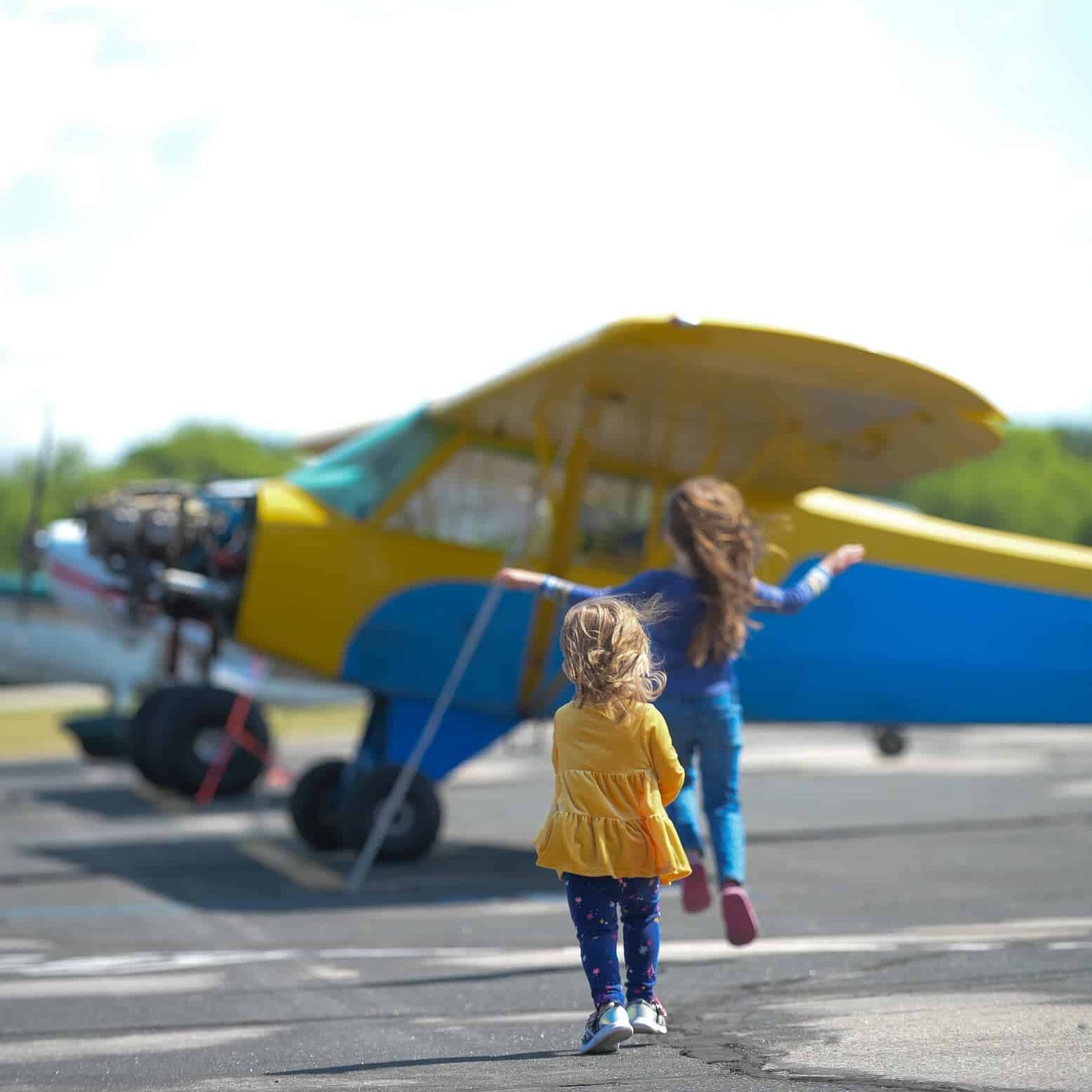 Two little girls skipping near plane